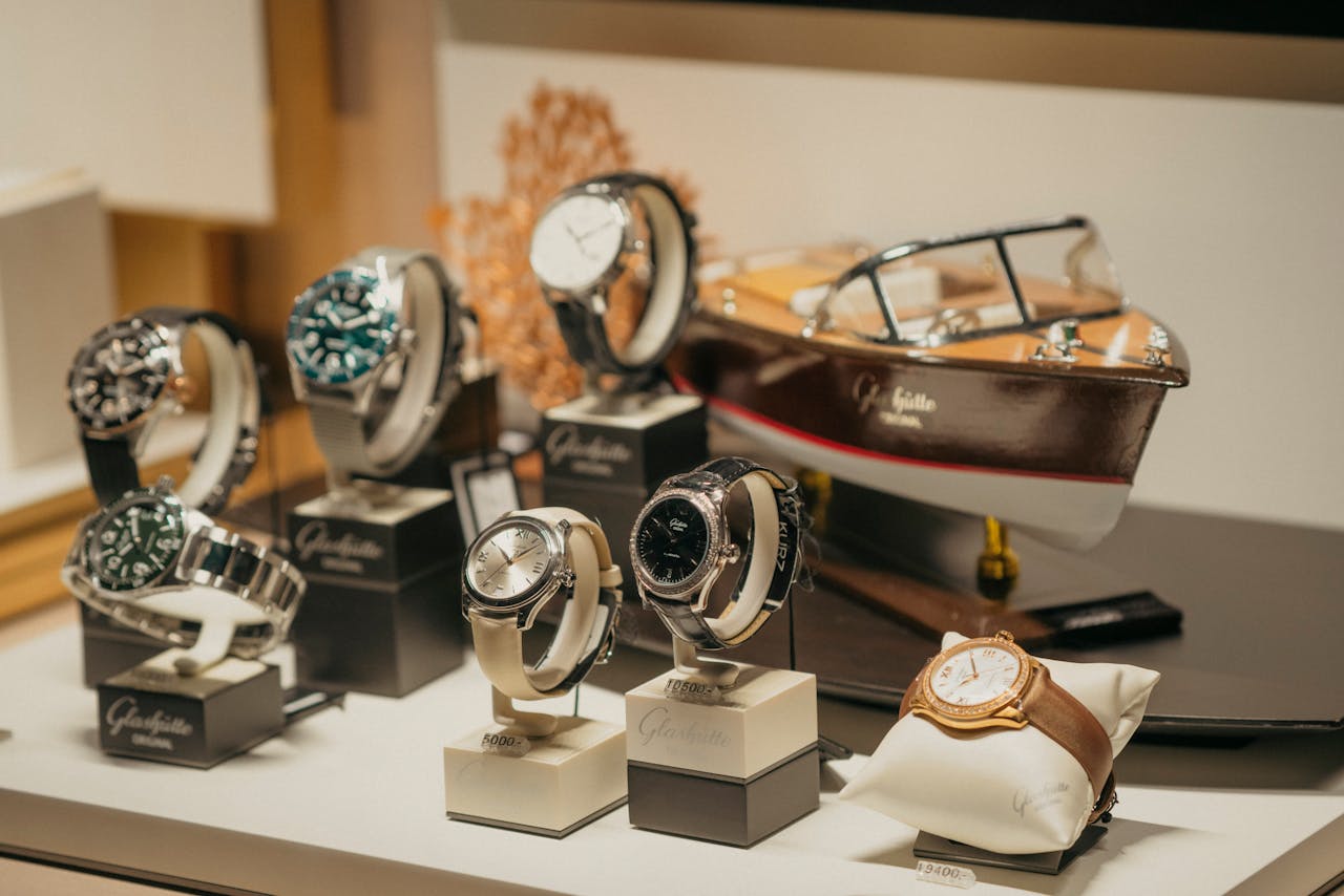A collection of luxury watches elegantly displayed beside a model boat in a retail environment.